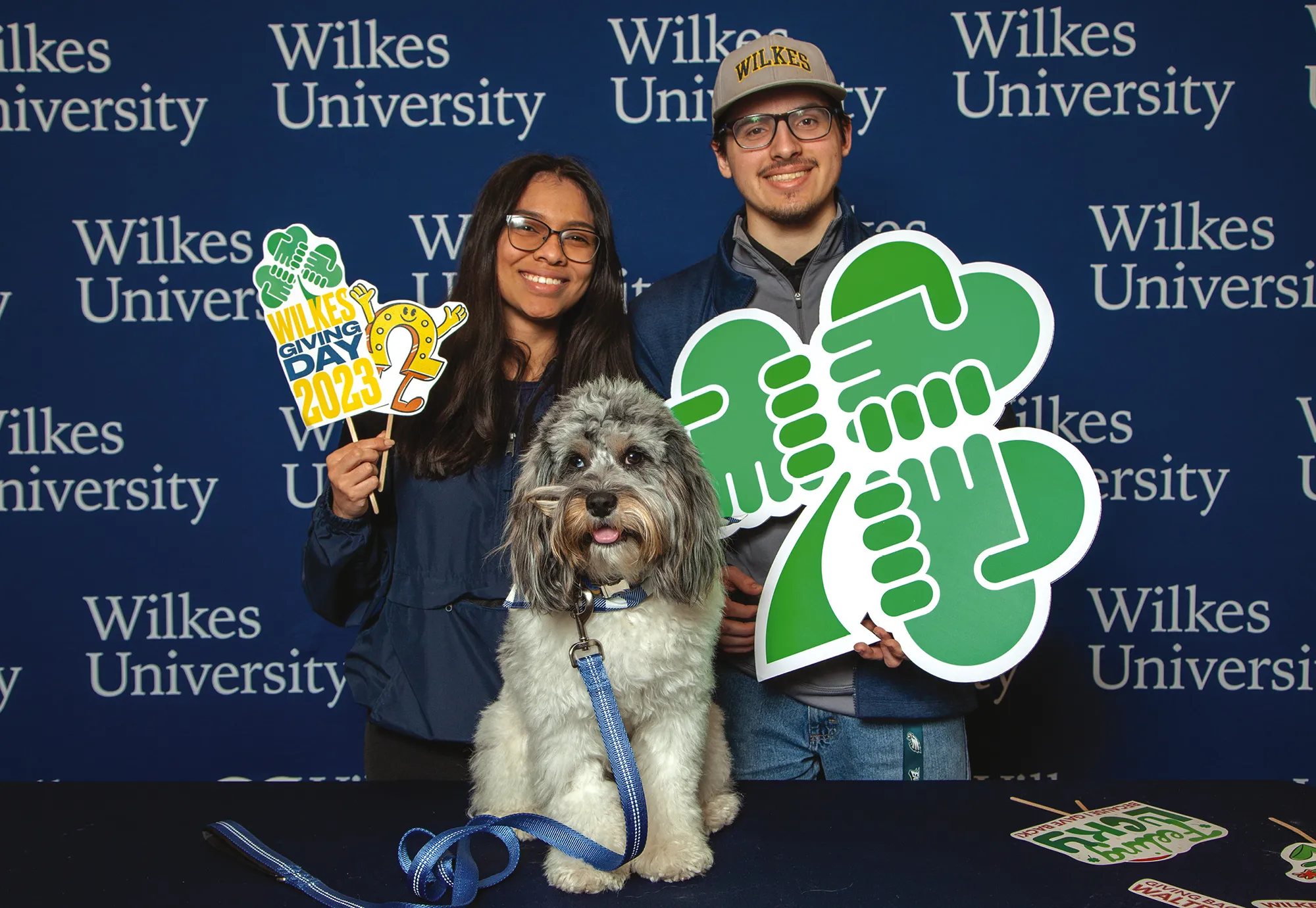 two students and a dog pose for Wilkes University Giving Day 2023