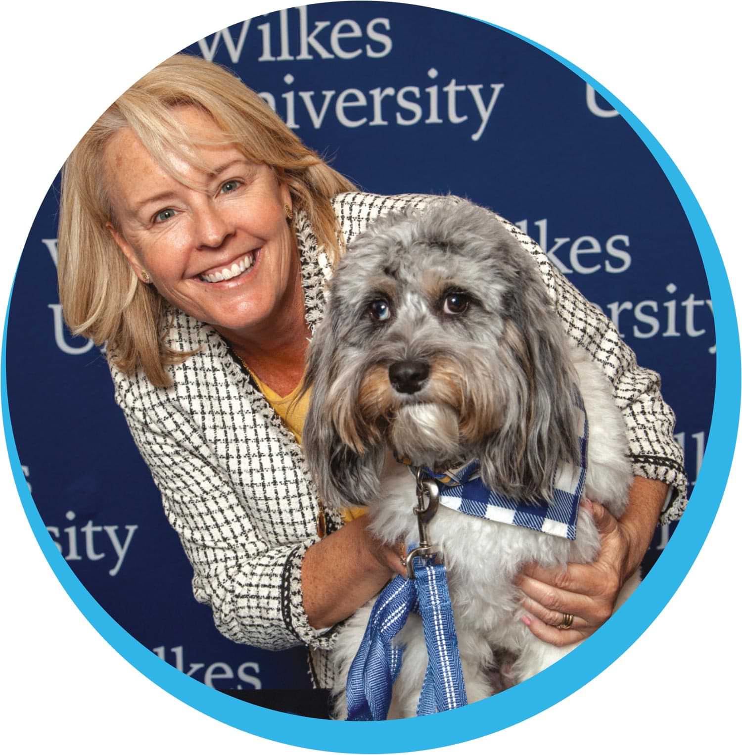 a smiling Angela Cant and Walter pictured in front of a Wilkes University step and repeat banner