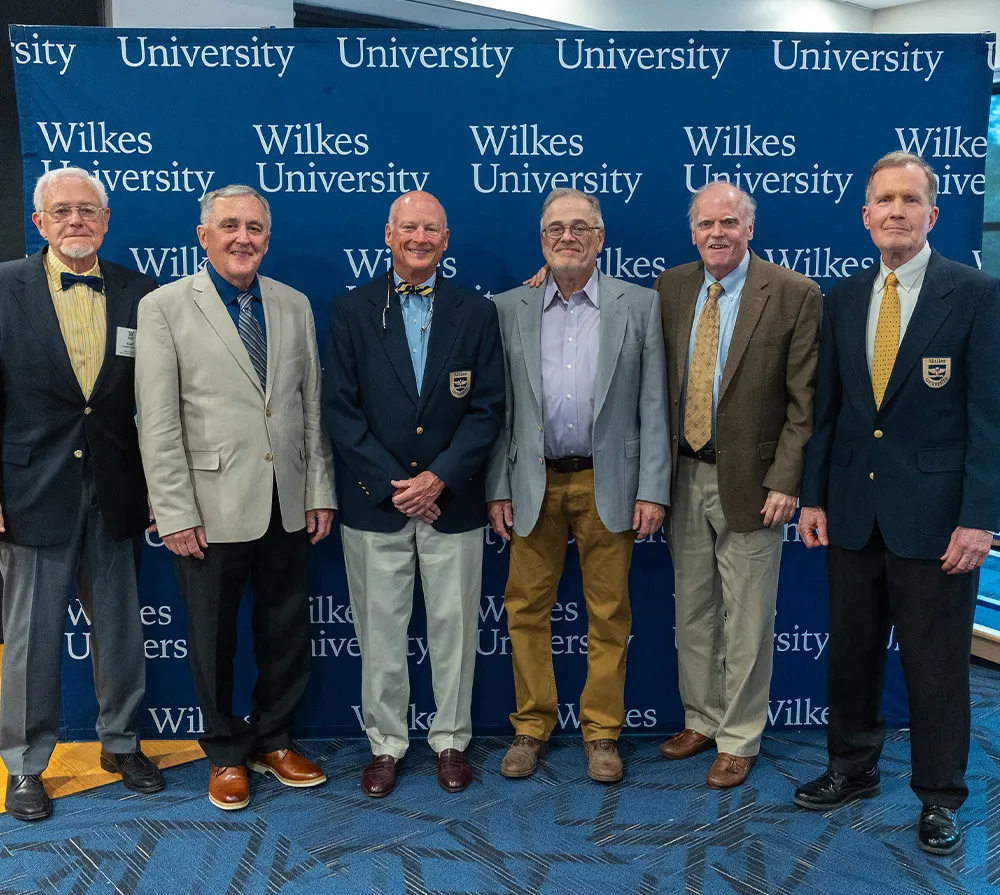 Professional group photo of six gentlemen, dressed in formal and semi-formal attire, at a Wilkes University event.