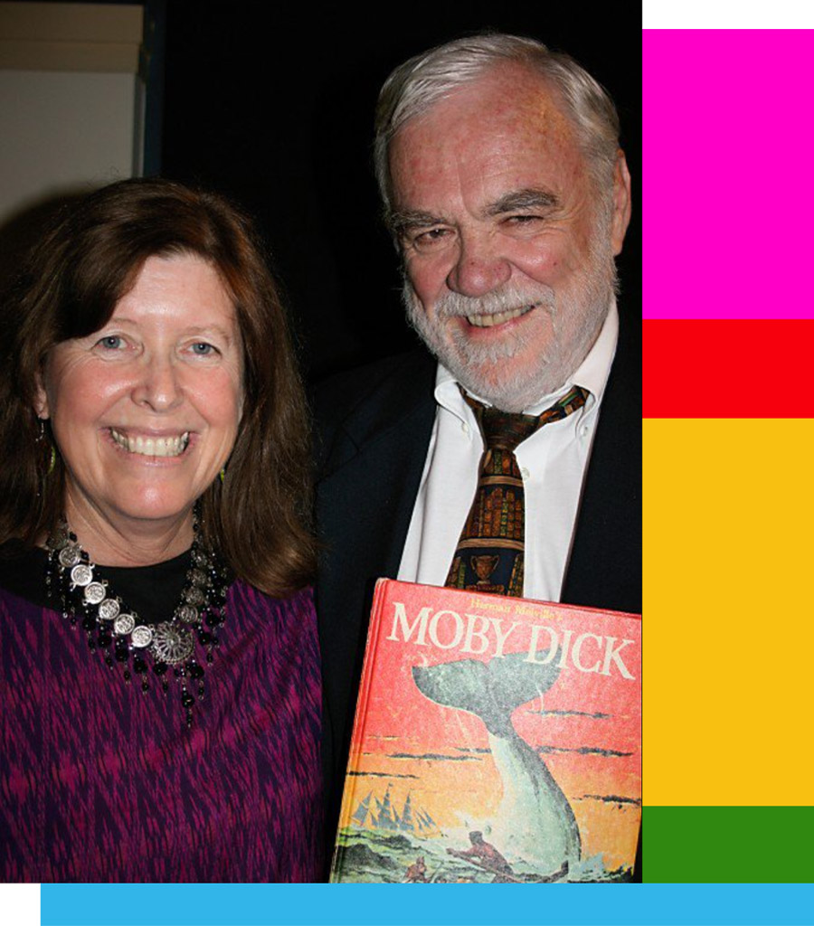 close portrait image of Nancy McKinley and Mike Lennon, both smile as Mike holds a copy of Moby Dick