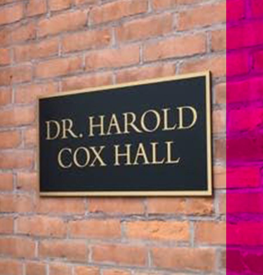 close angled view of the signage on the brick wall of Dr. Harold Cox Hall